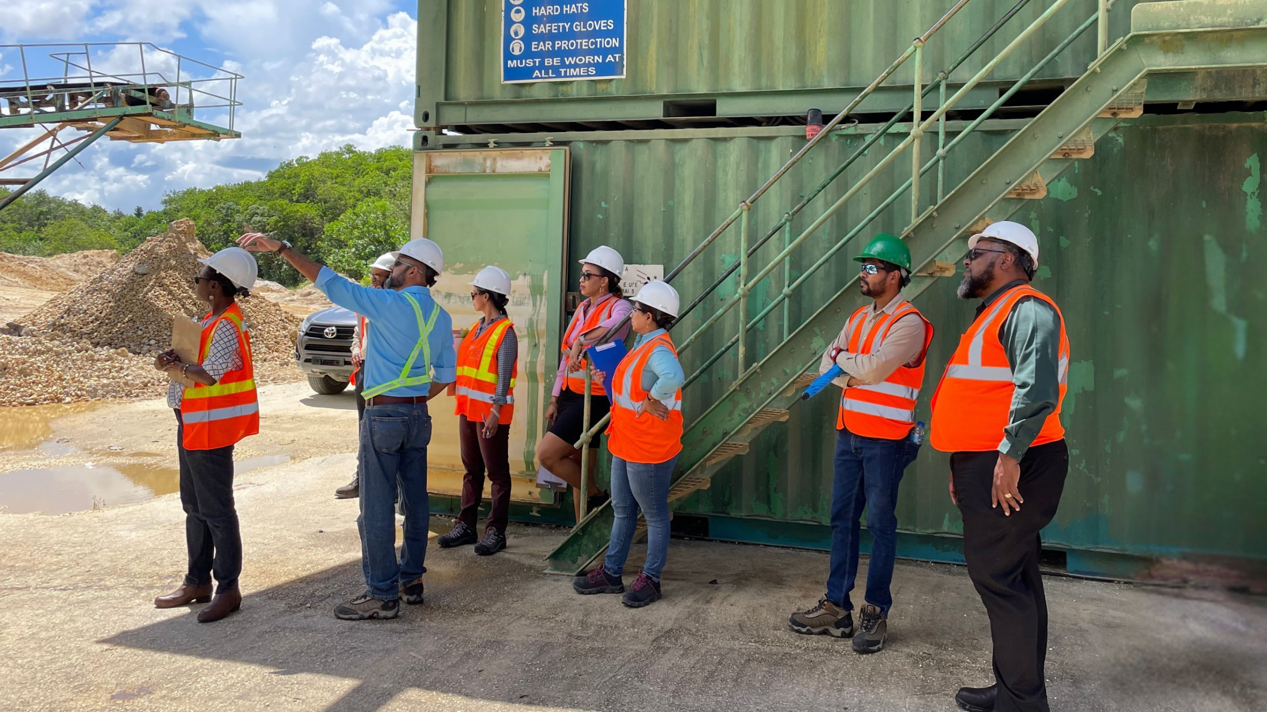 Members of the Executive Management team at National Quarries, outfitted in high-visibility safety vests and hard hats, gather for an on-site briefing at Sand & Gravel Division.