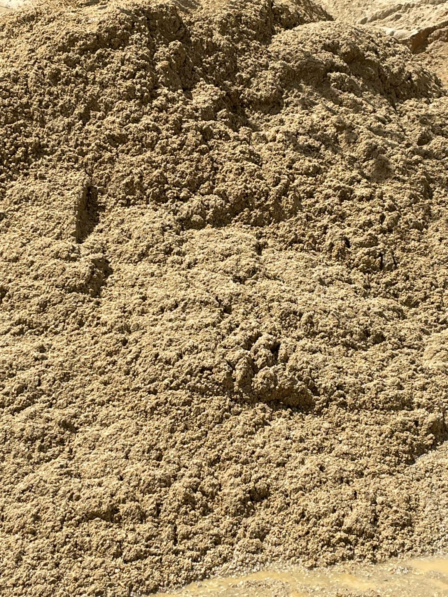 This image shows a pile of washed sand, likely used for masonry or concrete production. The sand has a fine, consistent texture and appears slightly damp, indicating recent washing to remove silt, clay, and other fine particles.